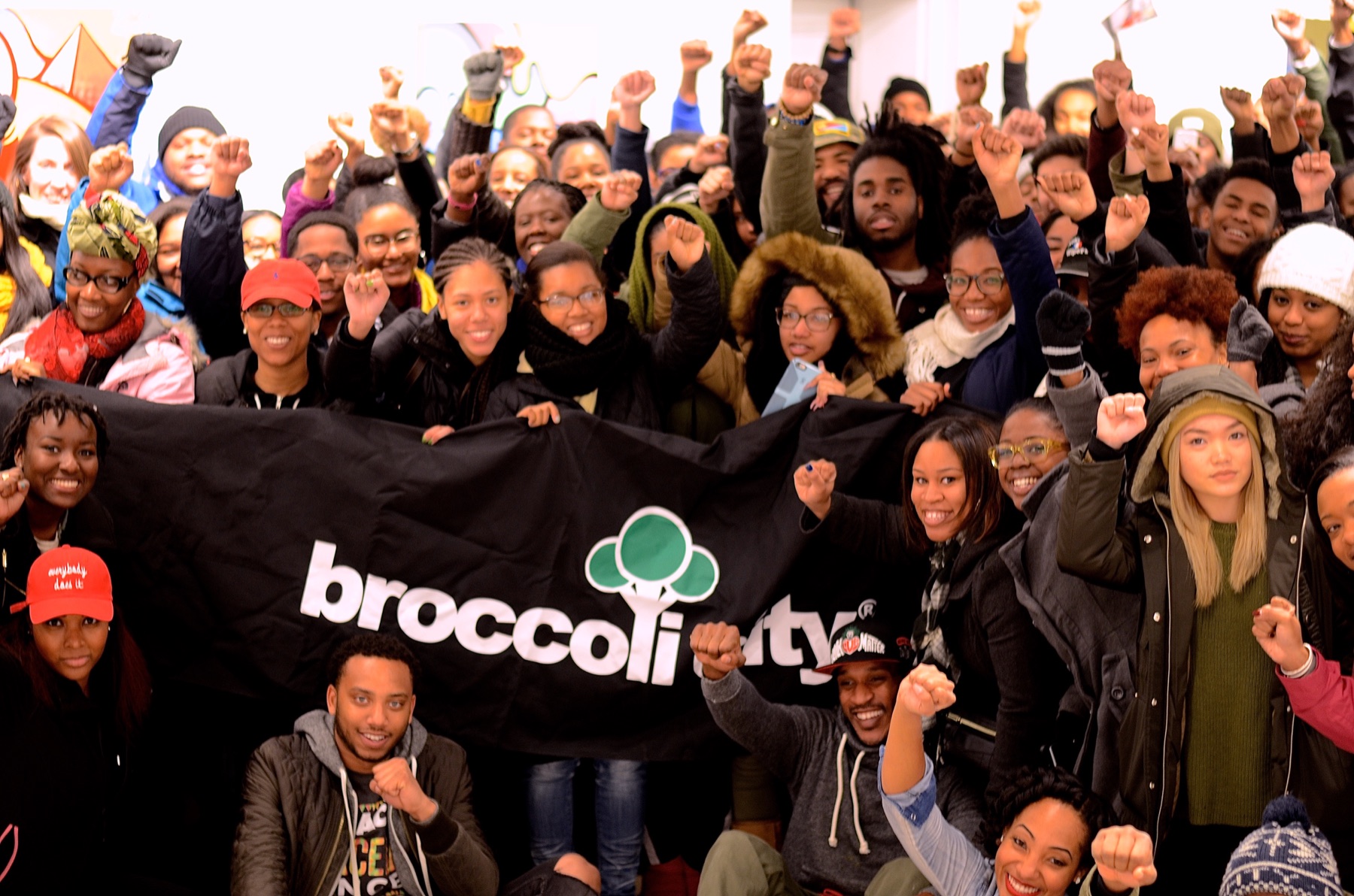 Broccoli City community group raising their fists with a banner