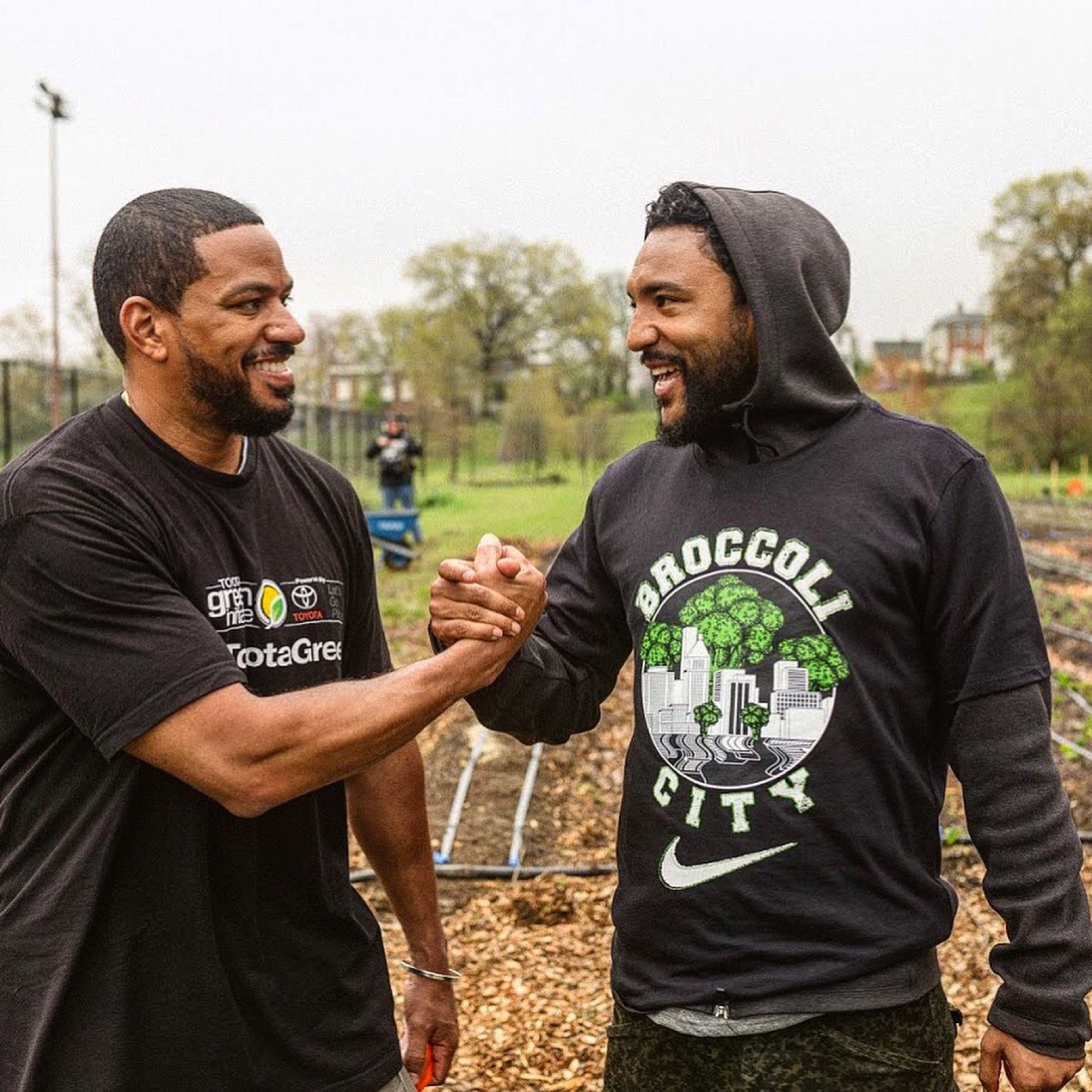 Two community leaders greeting each other at an urban garden activation