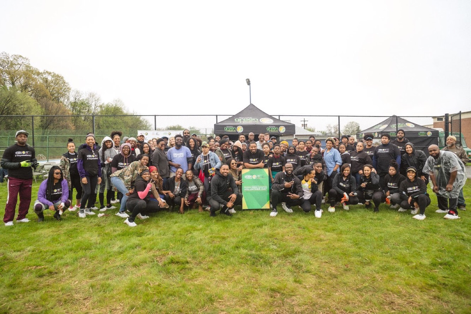 Large volunteer day group photo on a green field